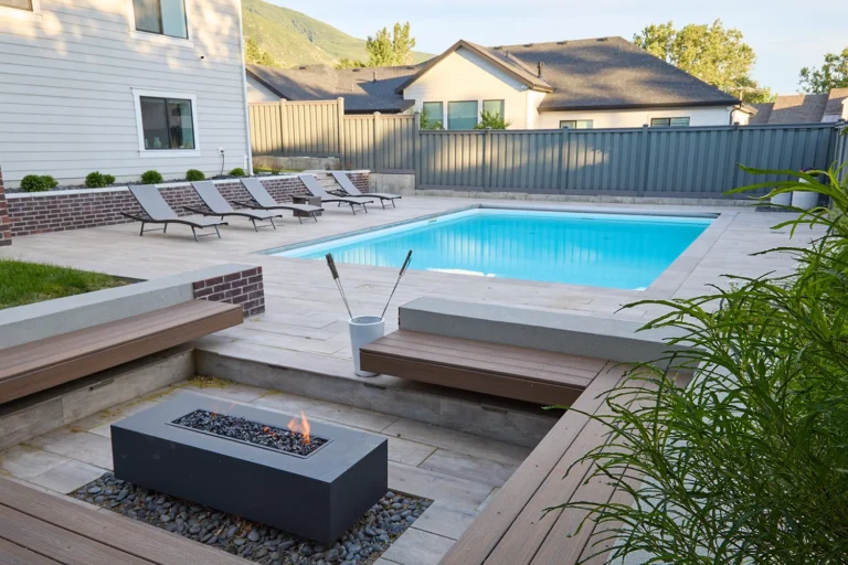 outdoor living with a custom fire pit and surrounding bench seats and a pool in the background