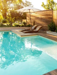 In ground pool with wood lounge chairs