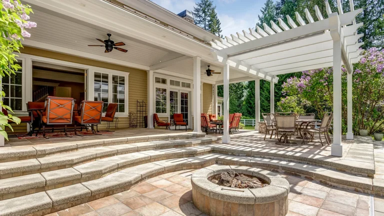 Lovely outdoor back patio space with white dining pergola.