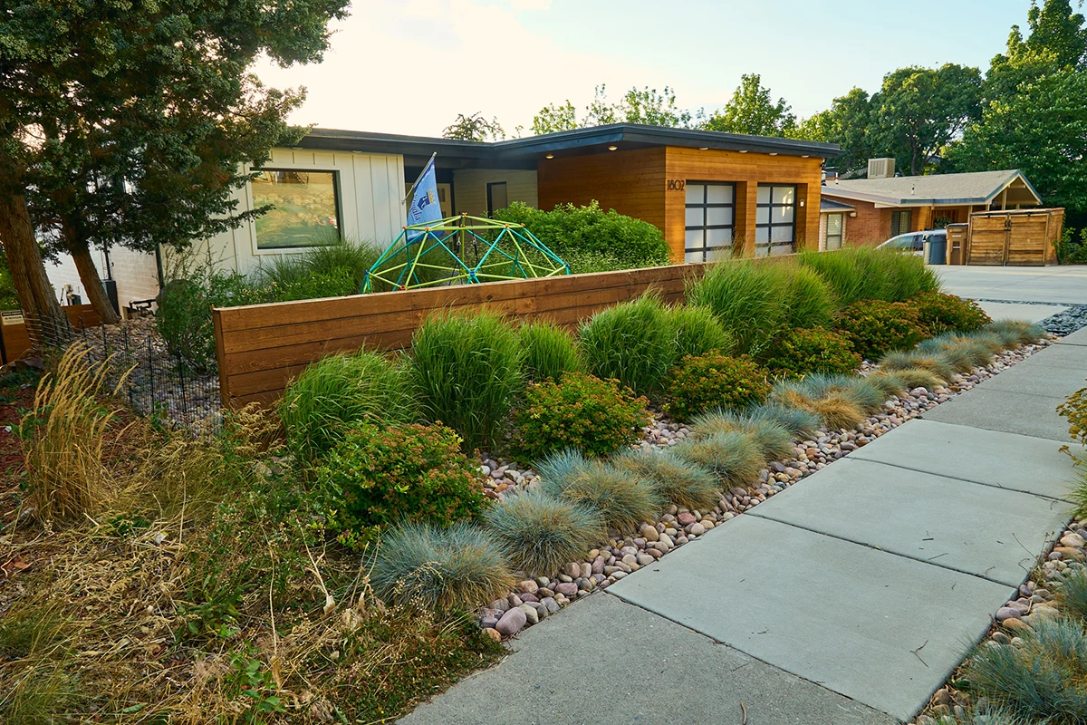 wide view of a home's front yard landscape featuring water wise plants